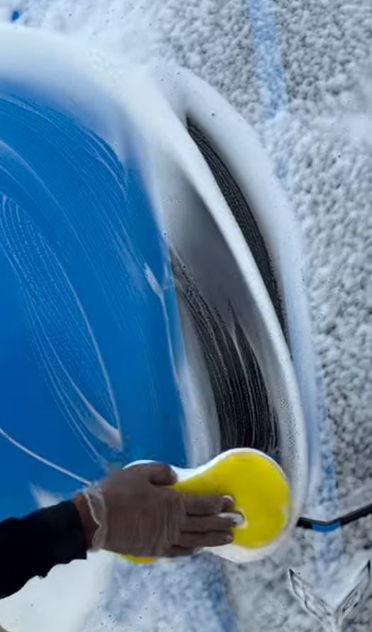 Hand foam wash on a wheel arch
